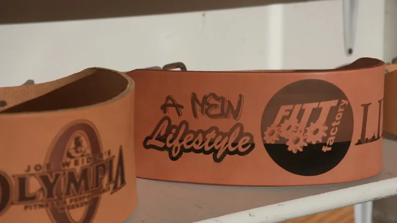 Laser tattooed Cardillo weight belts on a shelf