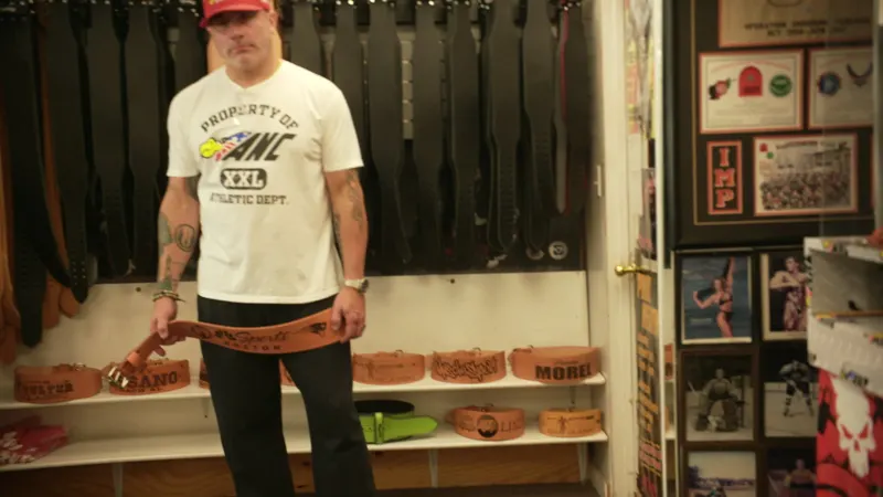 Peter Morel, owner of American Nutrition Center, holding a tattooed Cardillo belt in the showroom