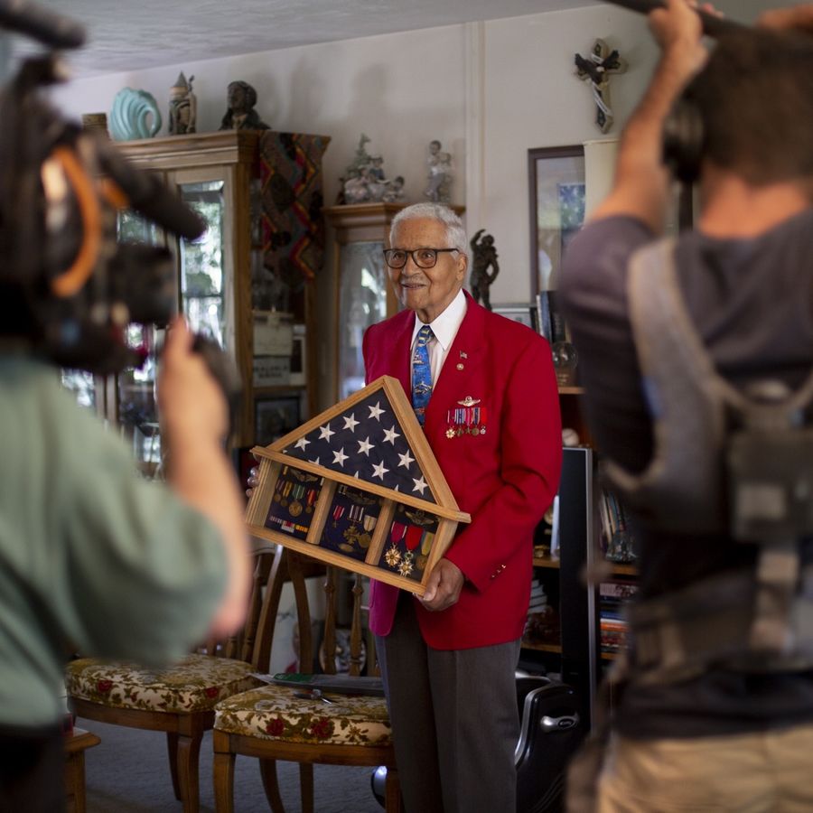 Crew and cameras around Colonel McGee, a Tuskegee Airman, in his home