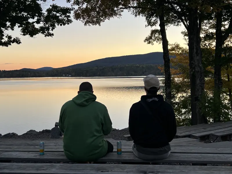 The crew on a bench at sunset over the lake after the PMC Unpaved Saturday