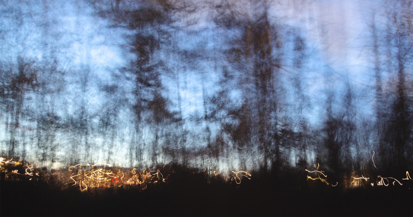Night Passage: bare winter trees at dusk with headlights streaking below, Beverly Farms, Massachusetts, intentional camera movement
